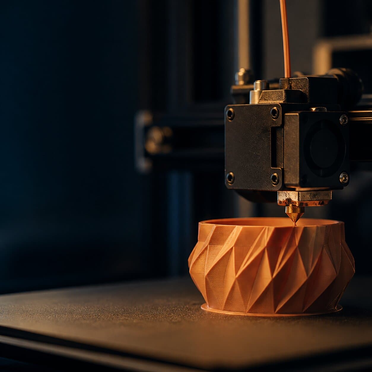 Close-up of the 3D printer nozzle printing a geometric terracotta bowl
